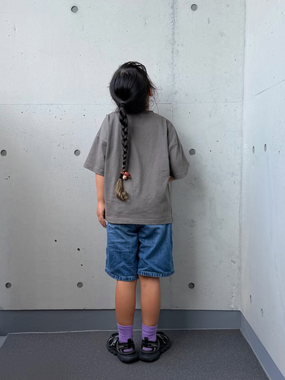 ブラック系のTシャツ/カットソー、ブラック系のサンダル、ブルー系のパンツを着用したキッズの夏コーディネートの2枚目の写真