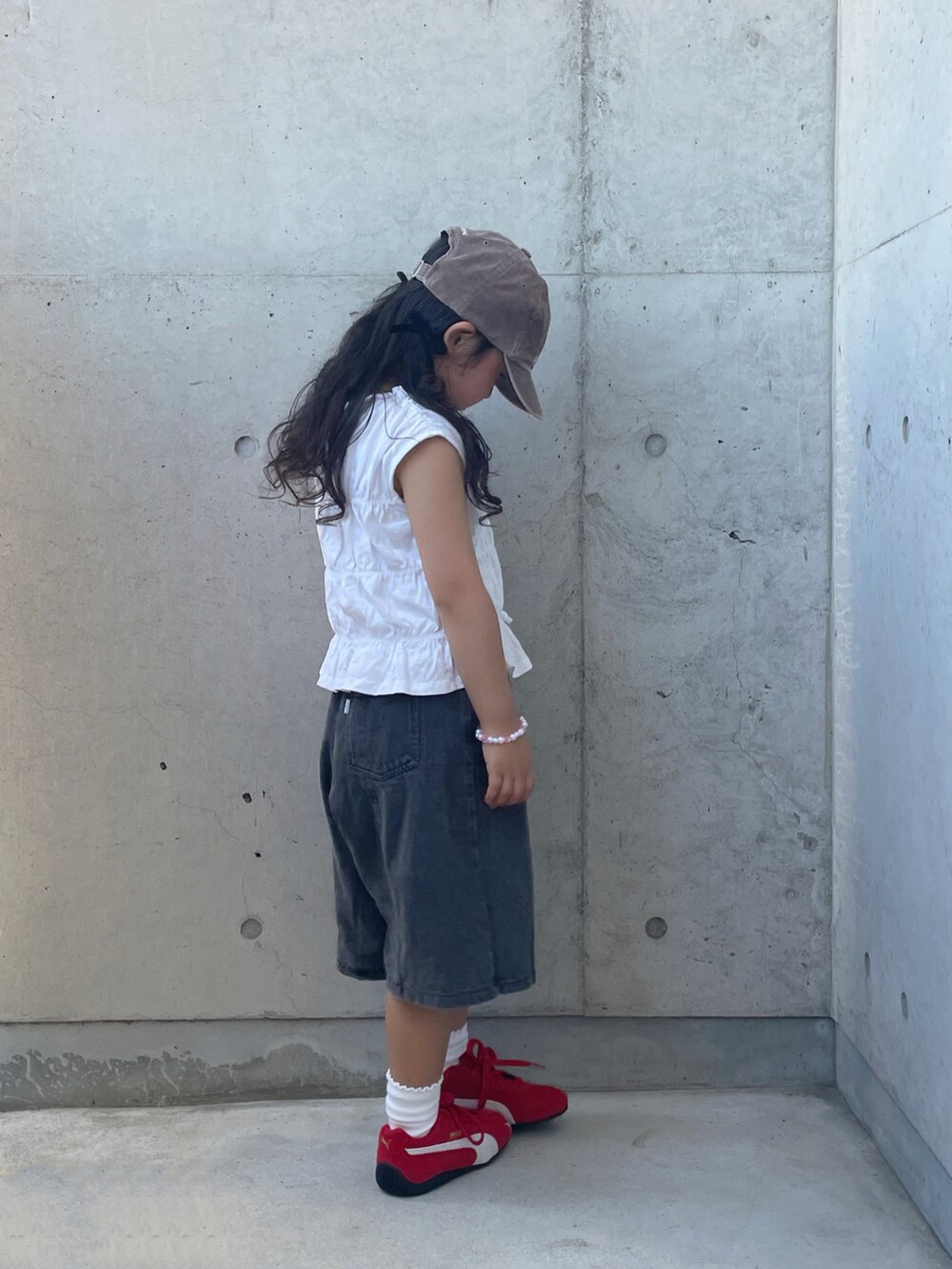 ブラック系のデニムパンツ、レッド系のスニーカー、ホワイト系のトップスを着用したキッズの夏コーディネートの2枚目の写真
