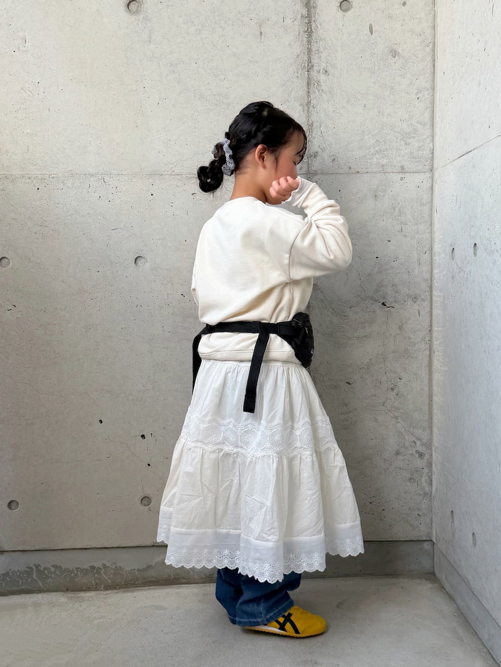 ホワイト系のスウェット、ブルー系のデニムパンツ、ブラック系のボディバッグ/ウエストポーチを着用したキッズの春コーディネートの4枚目の写真