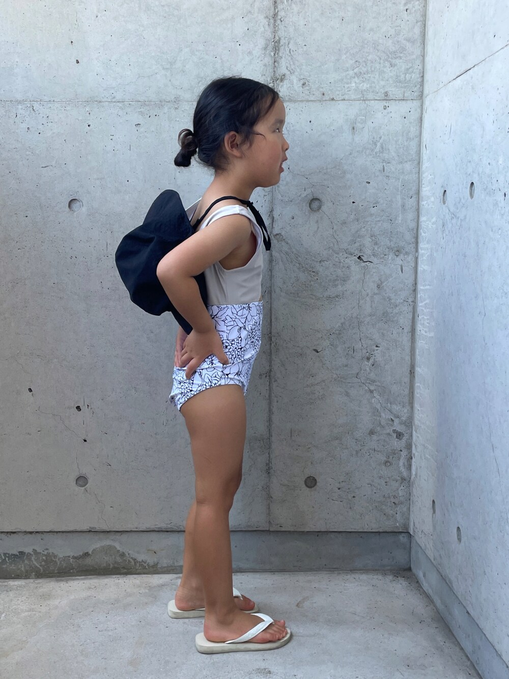 ホワイト系のサンダル、ブラック系のハット、ホワイト系の水着を着用したキッズの夏コーディネートの4枚目の写真