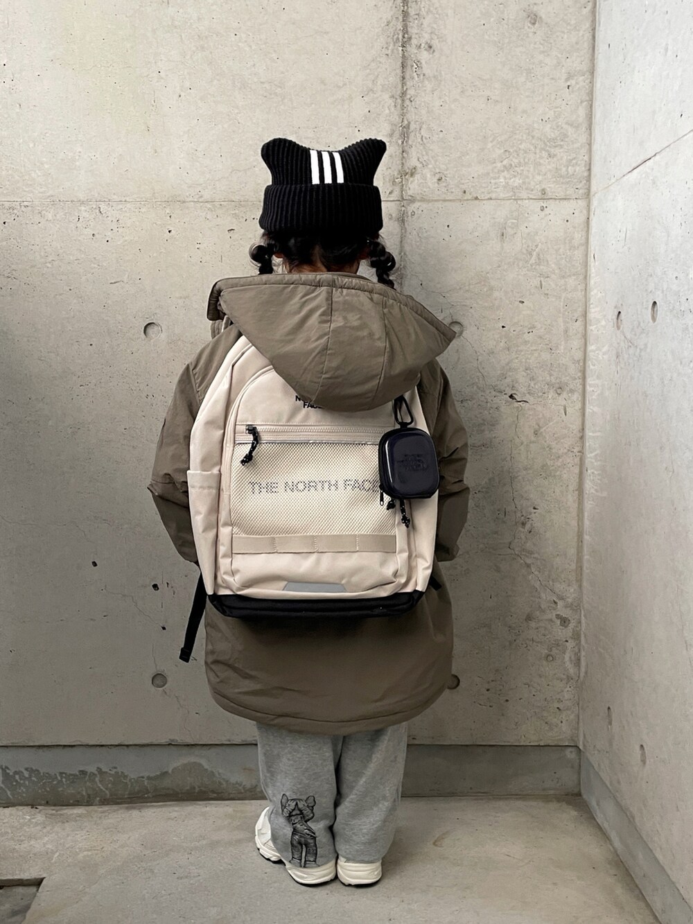 グリーン系のブルゾン、ホワイト系のバックパック/リュック、グレー系のパンツを着用したキッズの冬コーディネートの5枚目の写真