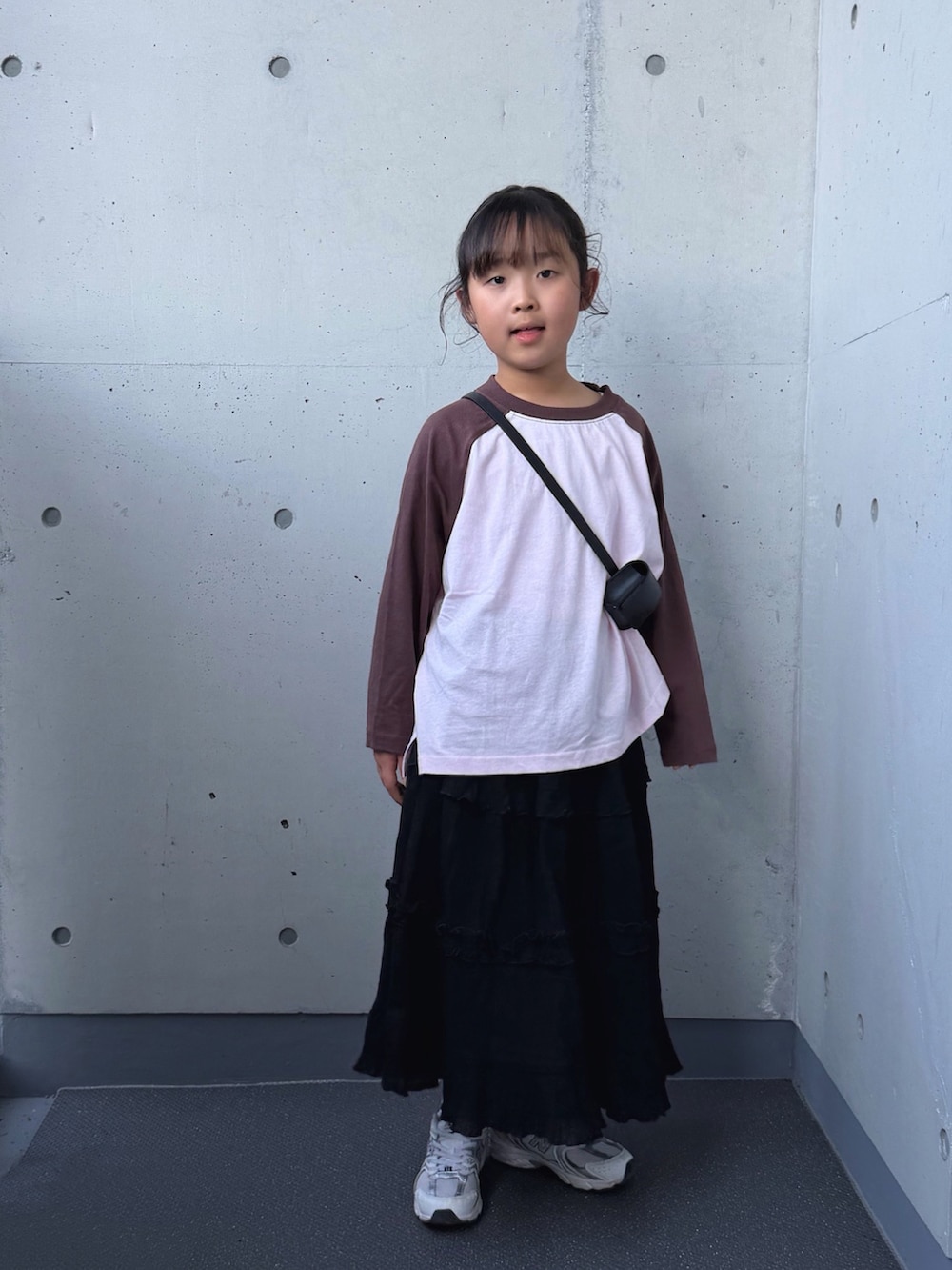 ホワイト系のスニーカー、ピンク系のTシャツ/カットソー、ブラック系のスカートを着用したキッズの秋コーディネートの5枚目の写真