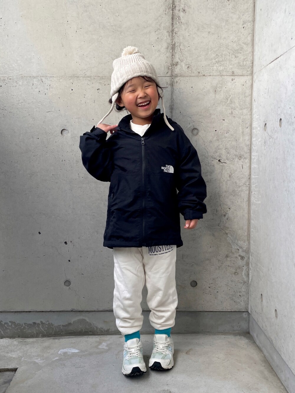 ブラック系のナイロンジャケット、ホワイト系のその他パンツ、ホワイト系のスウェットを着用したキッズの秋コーディネートの5枚目の写真