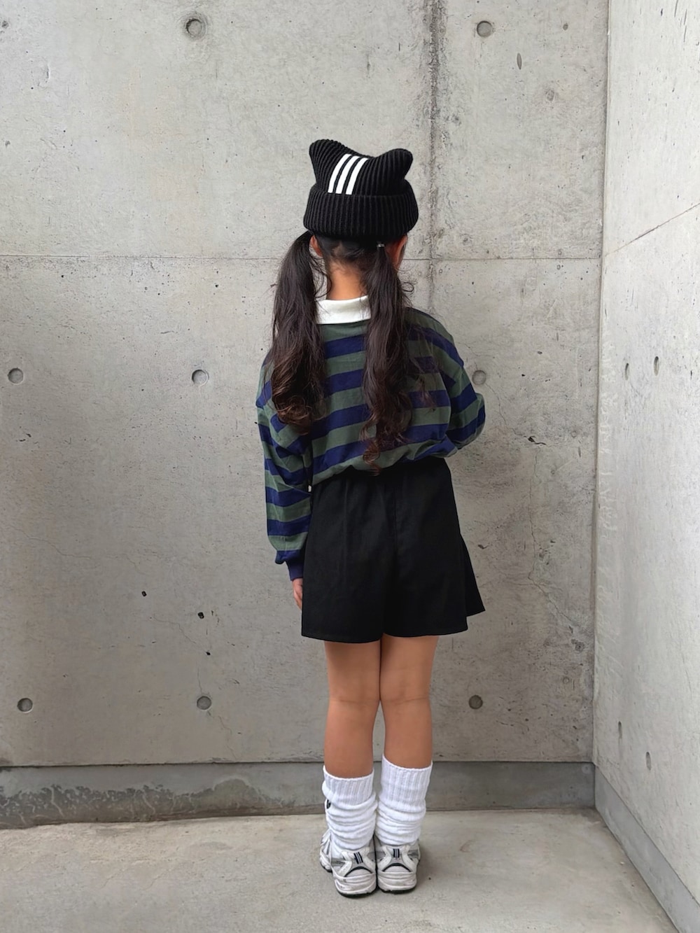 グリーン系のポロシャツ、ホワイト系のスニーカー、ブラック系のパンツを着用したキッズの冬コーディネートの3枚目の写真