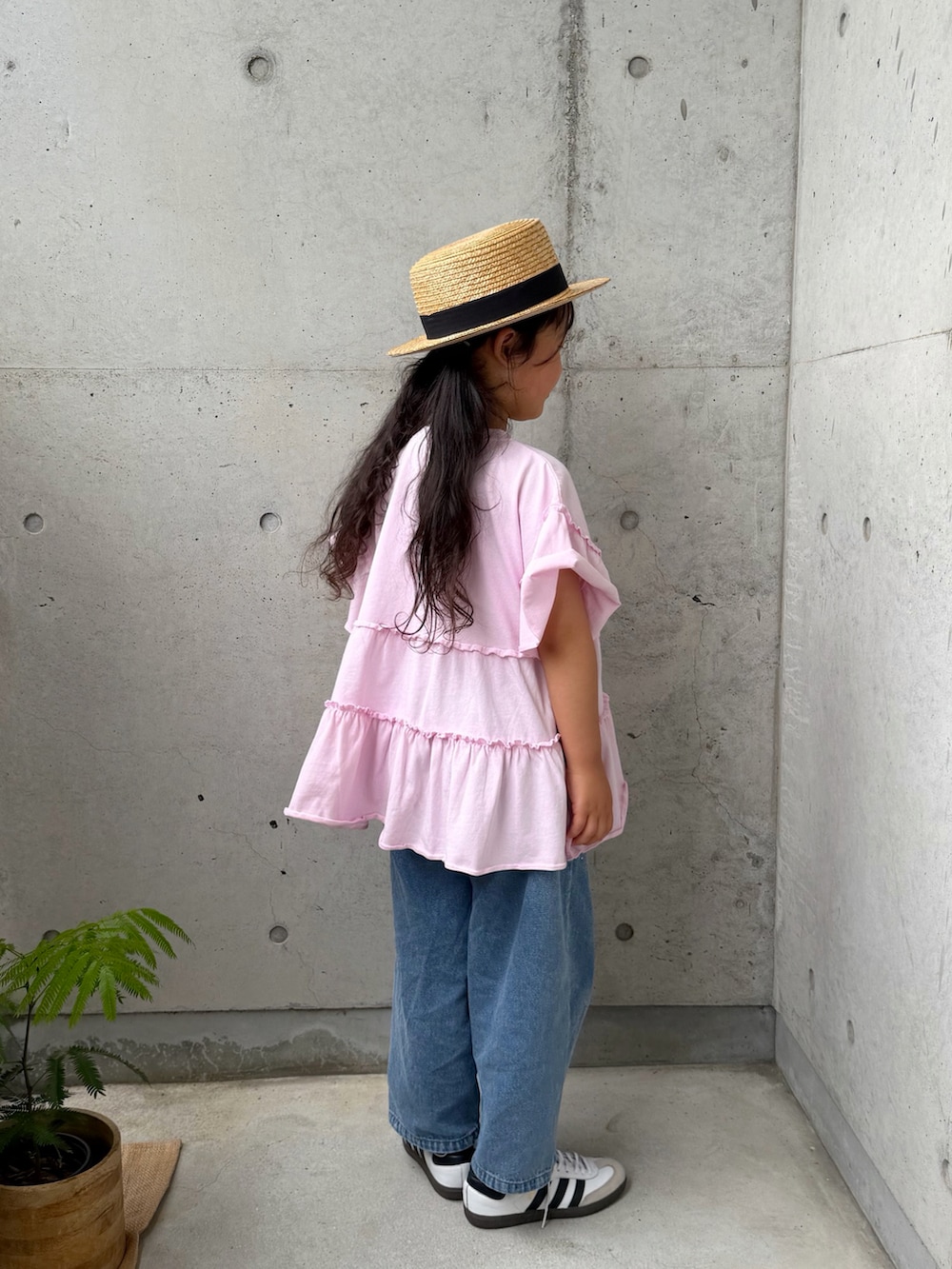 ピンク系のTシャツ/カットソー、ホワイト系のスニーカー、ブルー系のパンツを着用したキッズの春コーディネートの5枚目の写真