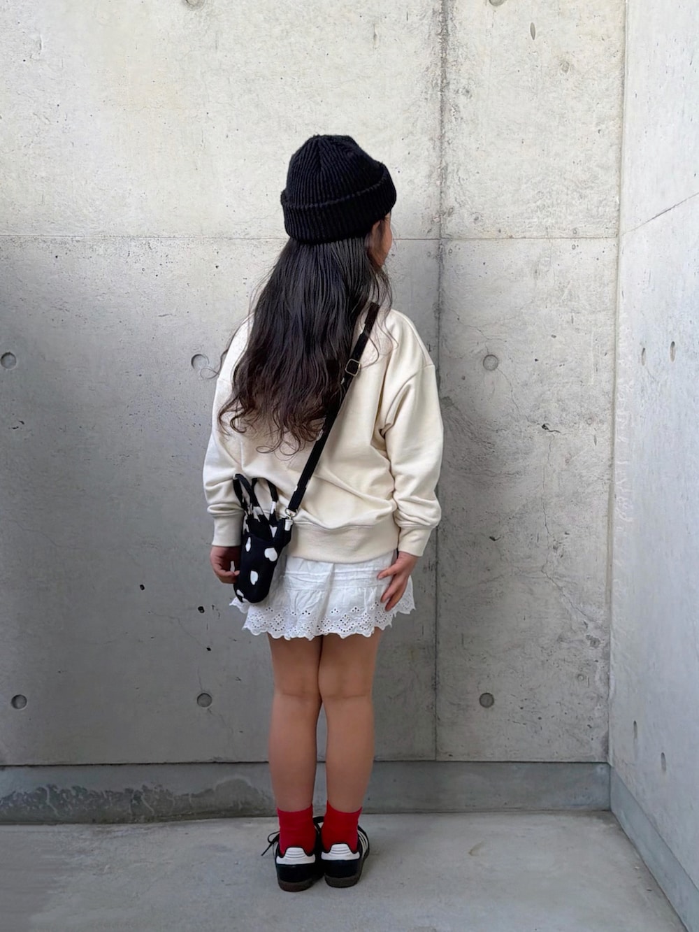 ホワイト系のスウェット、ブラック系のショルダーバッグ、ブラック系のスニーカーを着用したキッズの春コーディネートの3枚目の写真