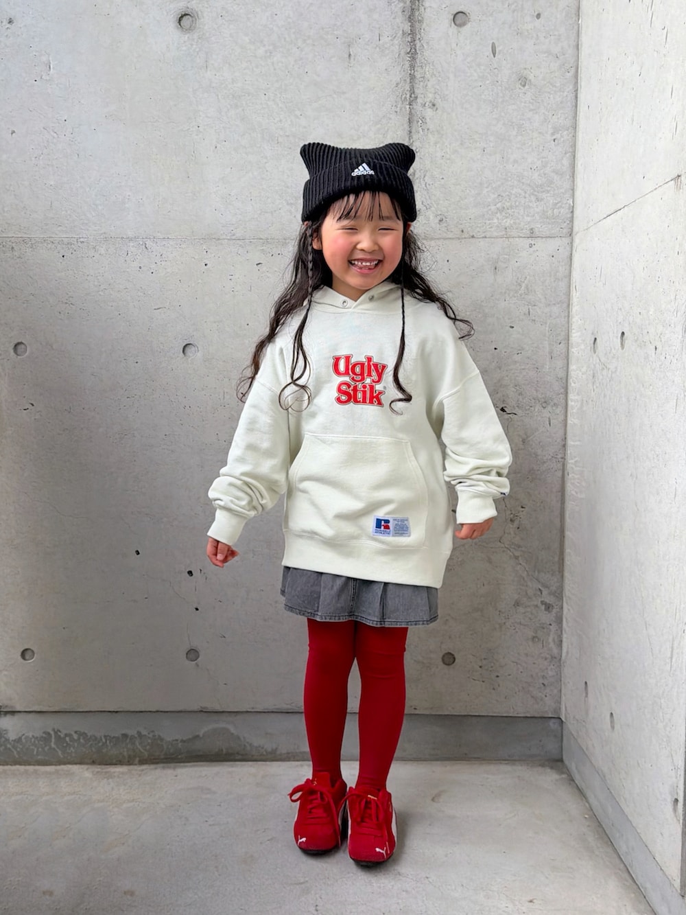 ホワイト系のパーカー、レッド系のスニーカー、グレー系のスカートを着用したキッズの冬コーディネートの5枚目の写真