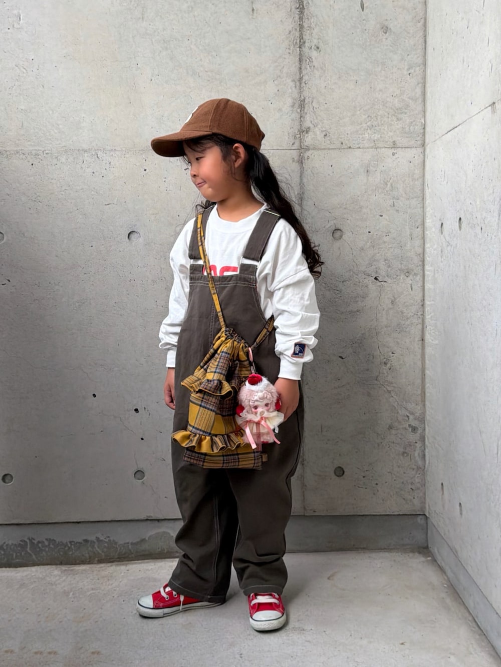 レッド系のスニーカー、グレー系のサロペット/オーバーオール、イエロー系のバックパック/リュックを着用したキッズの秋コーディネートの5枚目の写真