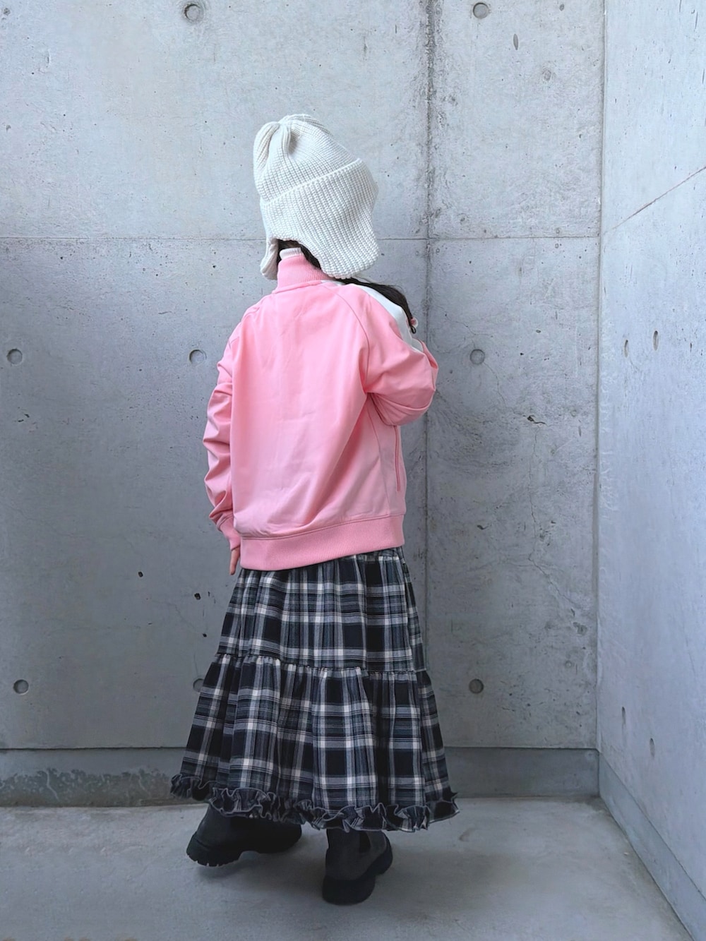 グレー系のブーツ、ピンク系のジャージ、ブラウン系のスカートを着用したキッズの冬コーディネートの4枚目の写真