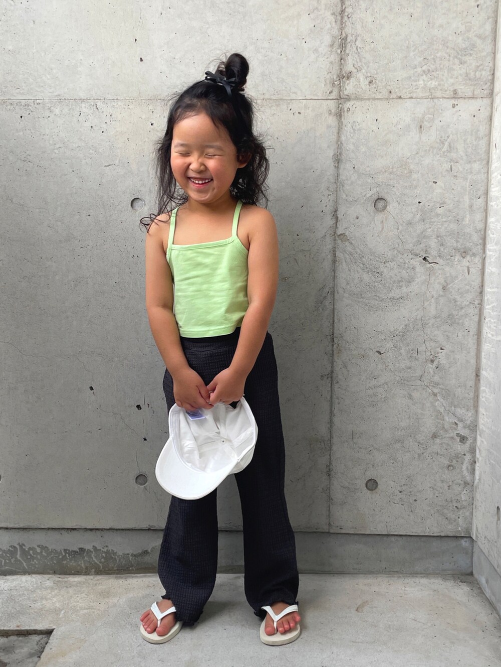 グリーン系のキャミソール、グレー系のその他パンツ、ホワイト系のサンダルを着用したキッズの夏コーディネートの2枚目の写真