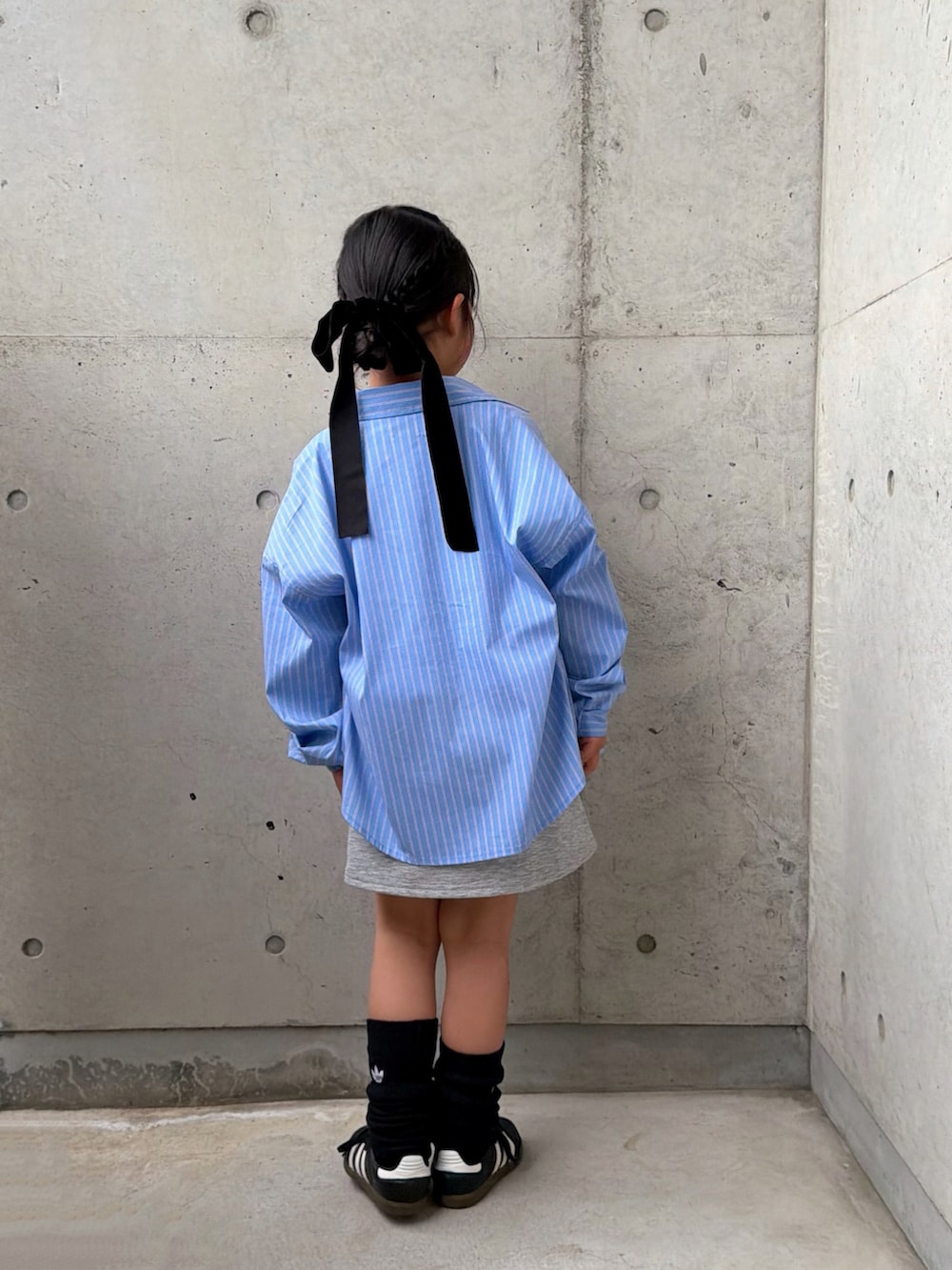 ブルー系のシャツ/ブラウス、ブラック系のシューズ、グレー系のスカートを着用したキッズの春コーディネートの2枚目の写真