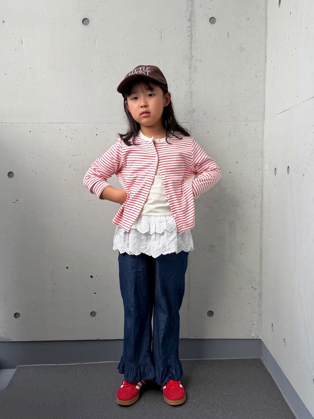 ブルー系のデニムパンツ、レッド系のスニーカー、レッド系のカーディガン/ボレロを着用したキッズの秋コーディネートの4枚目の写真
