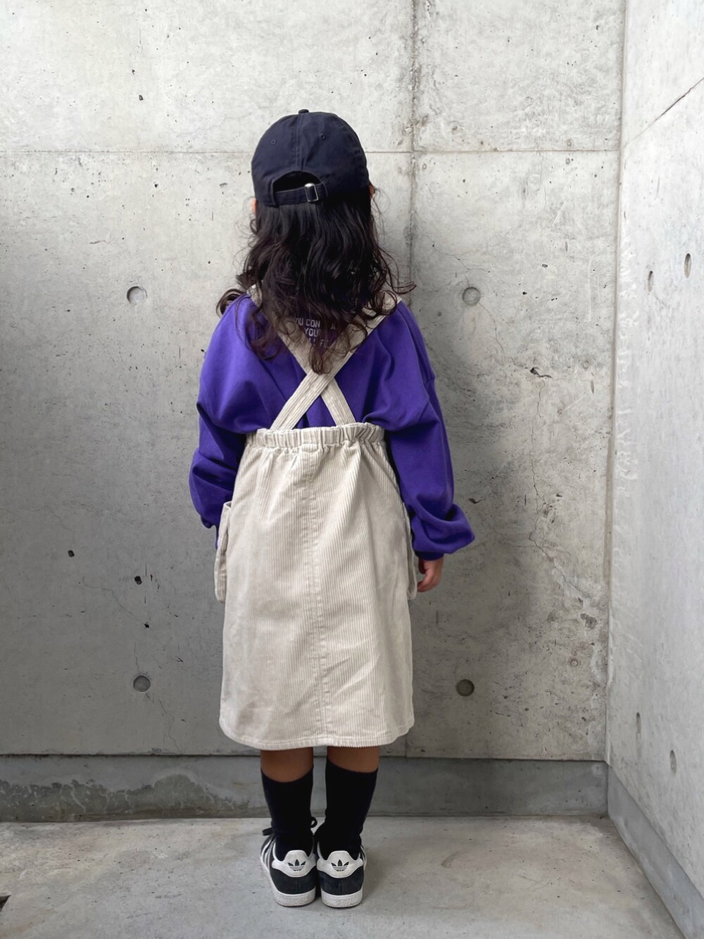ホワイト系のオールインワン・サロペット、パープル系のTシャツ/カットソー、ブラック系のスニーカーを着用したキッズの秋コーディネートの3枚目の写真