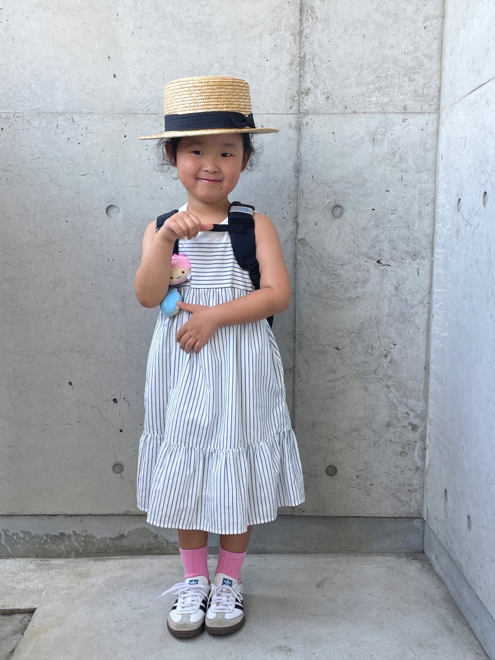 ホワイト系のワンピース/ドレス、ホワイト系のスニーカー、ブラック系のバックパック/リュックを着用したキッズの夏コーディネートの5枚目の写真