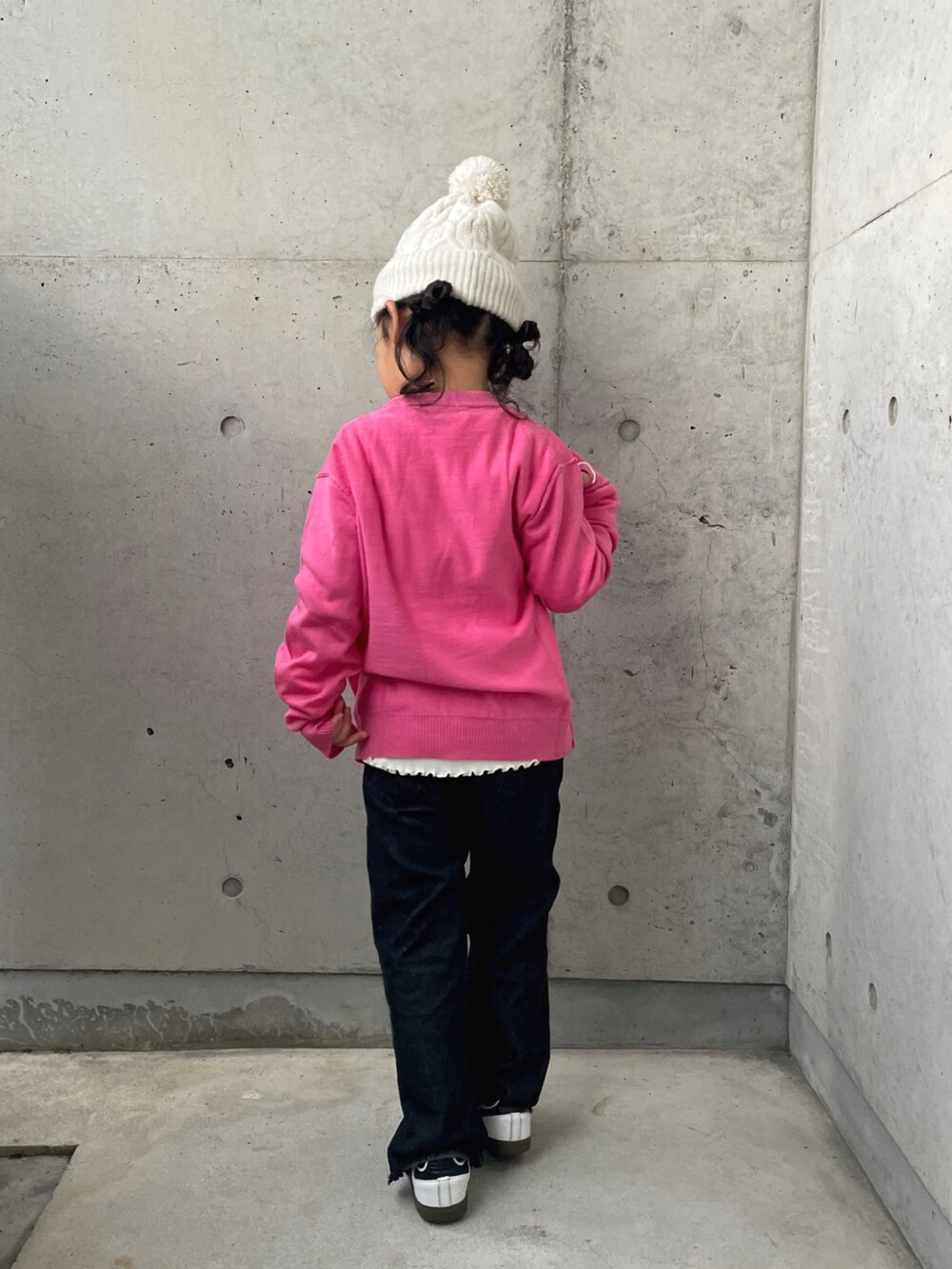 ブラック系のパンツ、ピンク系のニット/セーター、ホワイト系のTシャツ/カットソーを着用したキッズの秋コーディネートの3枚目の写真