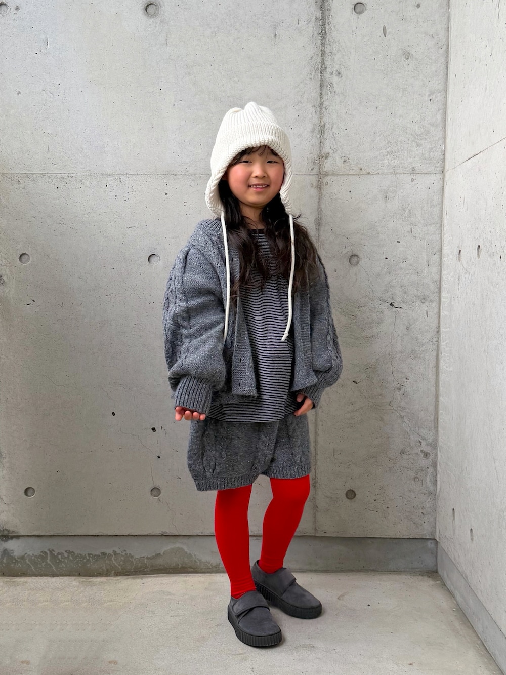 グレー系のニット/セーター、グレー系のその他パンツ、ブラック系のTシャツ/カットソーを着用したキッズの冬コーディネートの4枚目の写真