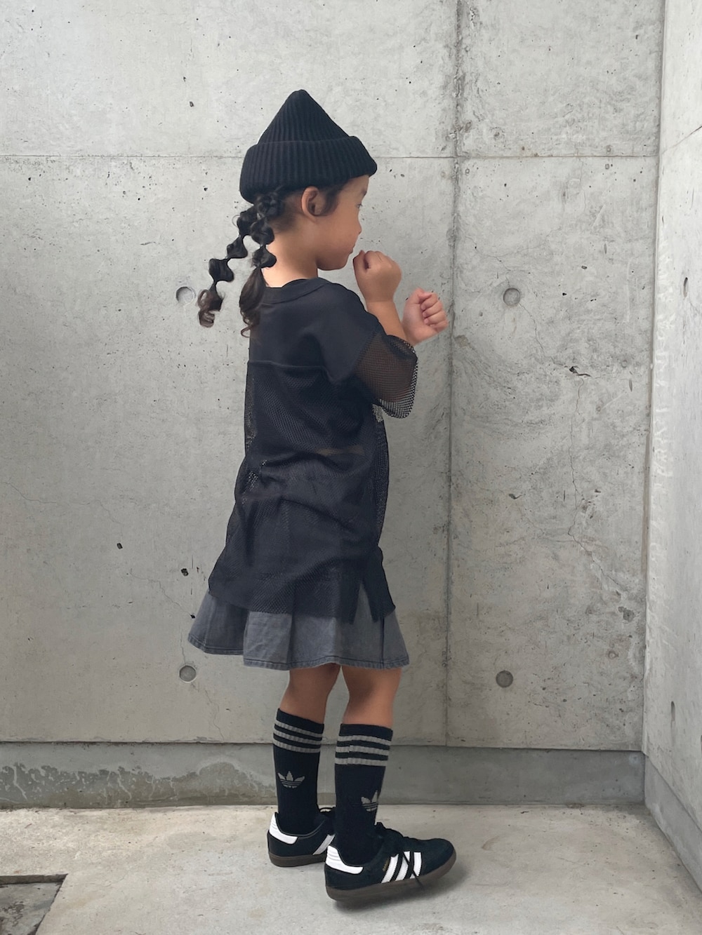 グレー系のスカート、ブラック系のキャミソール、ブラック系のTシャツ/カットソーを着用したキッズの秋コーディネートの2枚目の写真