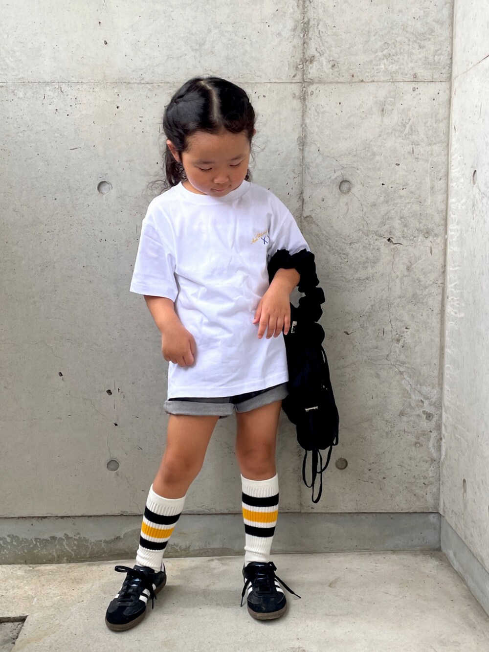 ホワイト系のトップス、グレー系のパンツ、ホワイト系のスニーカーを着用したキッズの秋コーディネートの3枚目の写真