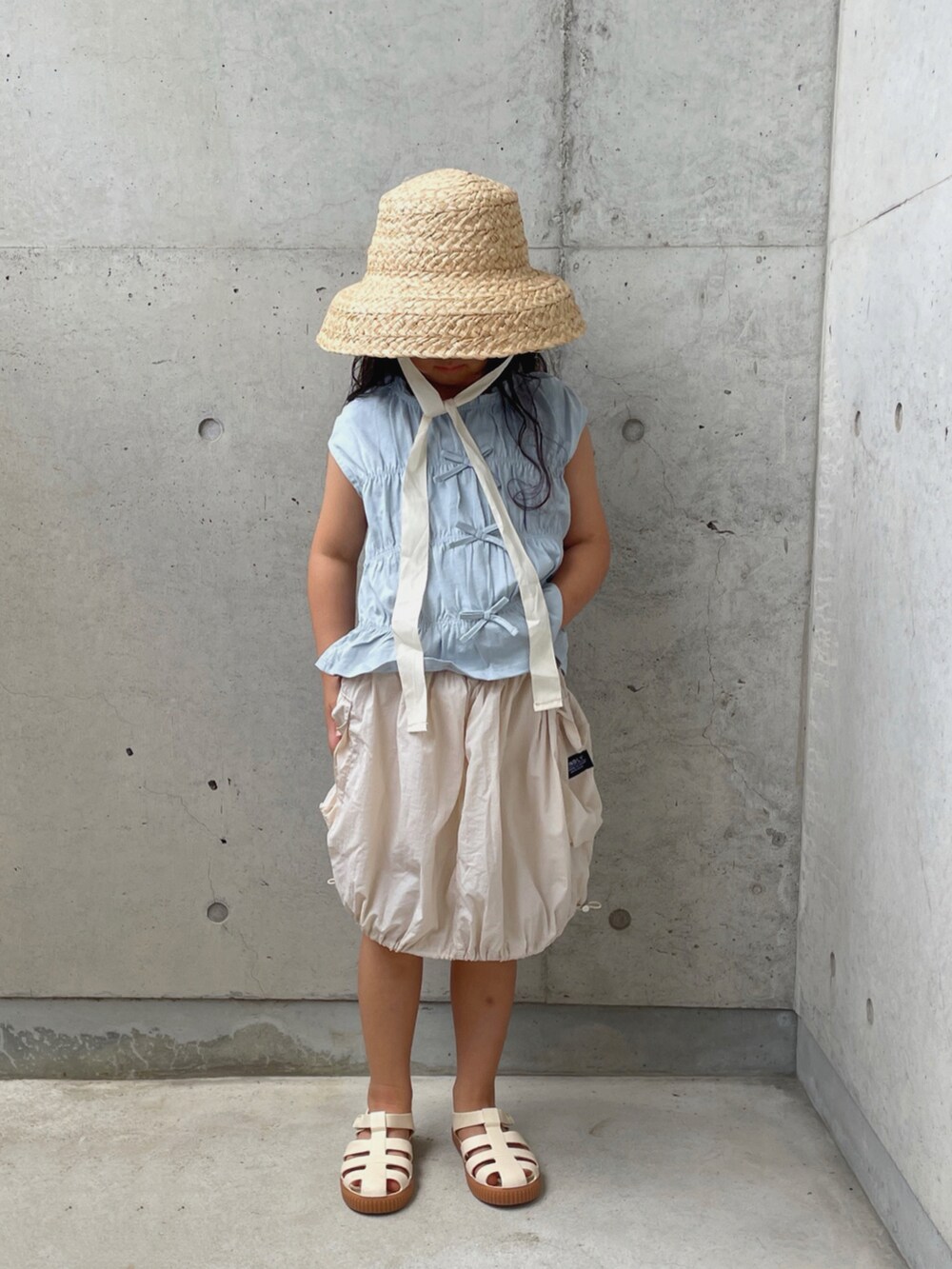 ホワイト系のサンダル、ホワイト系のスカート、ブルー系のトップスを着用したキッズの夏コーディネートの5枚目の写真