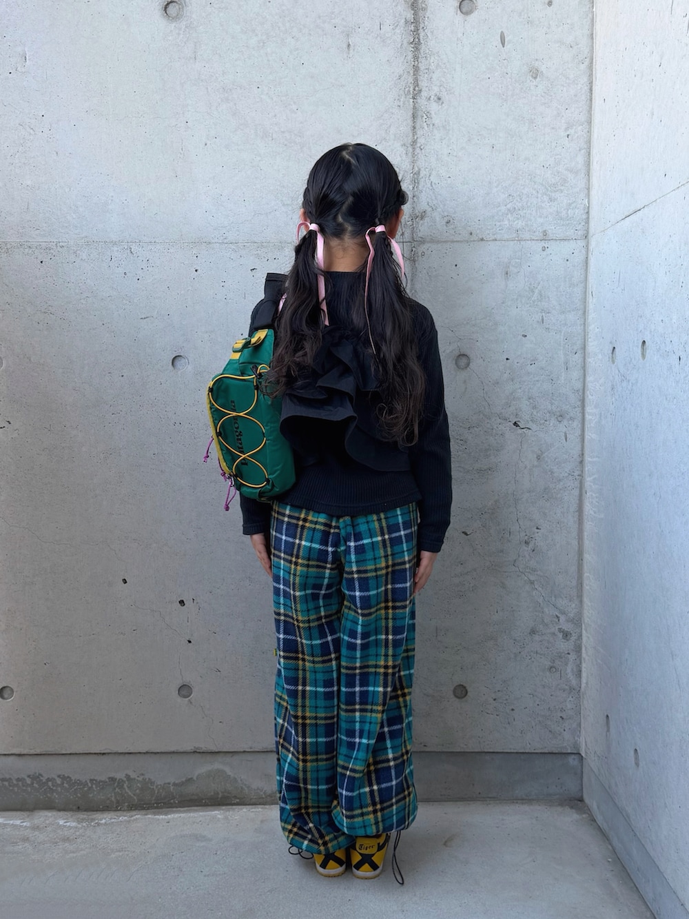 イエロー系のスニーカー、ブラック系のTシャツ/カットソー、グリーン系のパンツを着用したキッズの春コーディネートの4枚目の写真