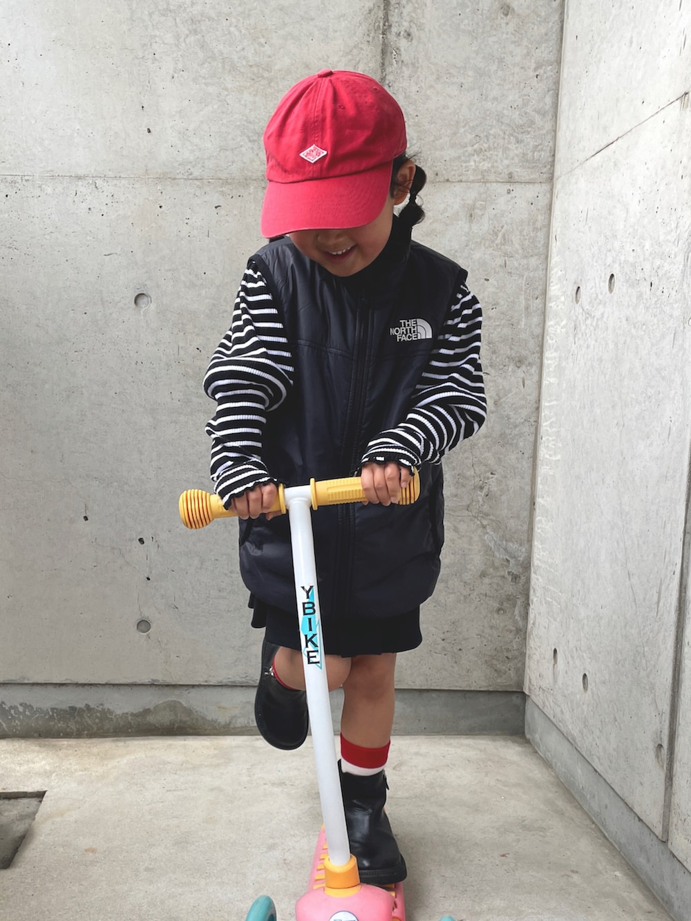 ブラック系のベスト、グレー系のワンピース、ブラック系のブーツを着用したキッズの春コーディネートの4枚目の写真