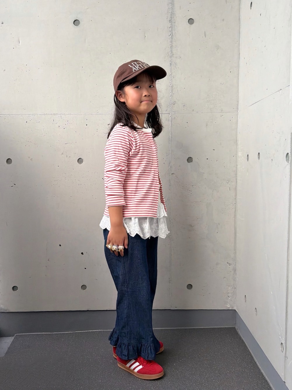 ブルー系のデニムパンツ、レッド系のスニーカー、レッド系のカーディガン/ボレロを着用したキッズの秋コーディネートの5枚目の写真