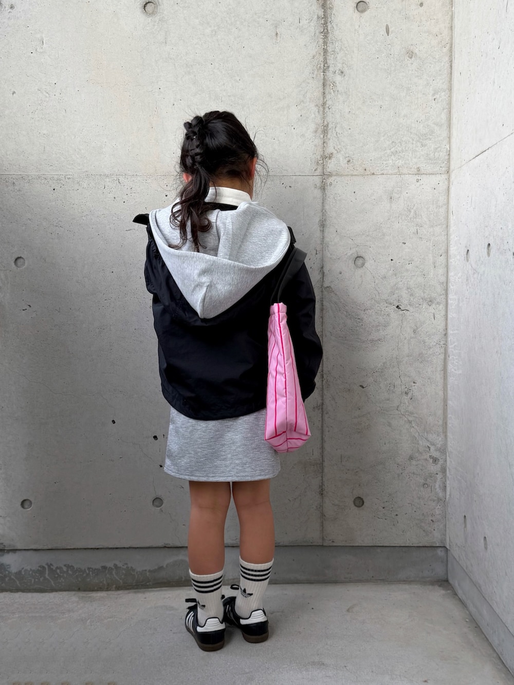 ブラック系のスニーカー、ブラック系のマウンテンパーカー、グレー系のパーカーを着用したキッズの冬コーディネートの3枚目の写真