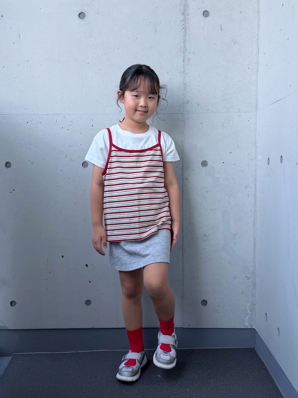 ホワイト系のTシャツ/カットソー、シルバー系のスニーカー、グレー系のスカートを着用したキッズの秋コーディネートの5枚目の写真