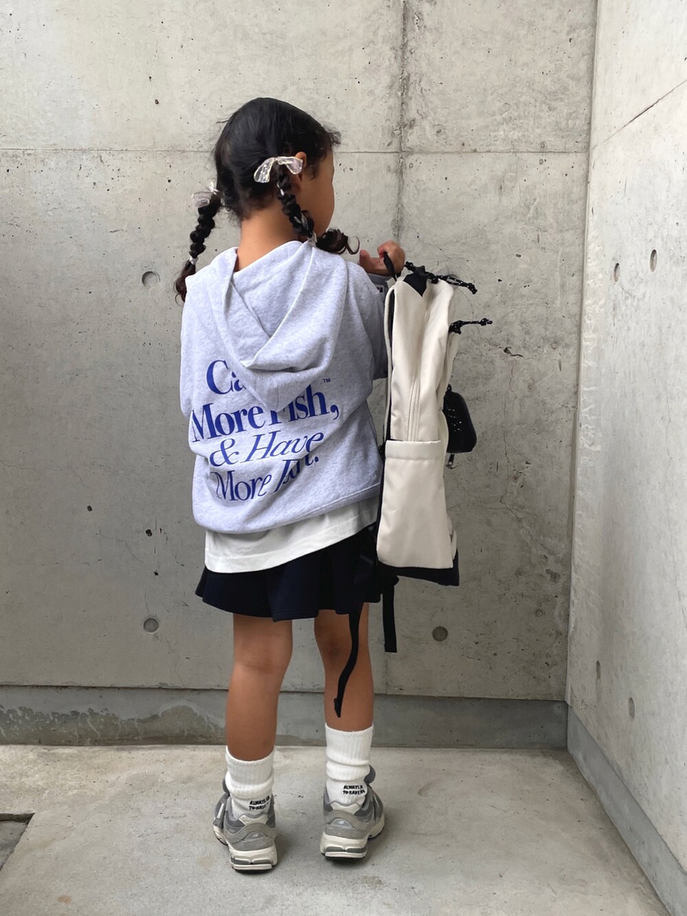 グレー系のスウェット、ホワイト系のTシャツ/カットソー、ブラック系のスカートを着用したキッズの秋コーディネートの2枚目の写真