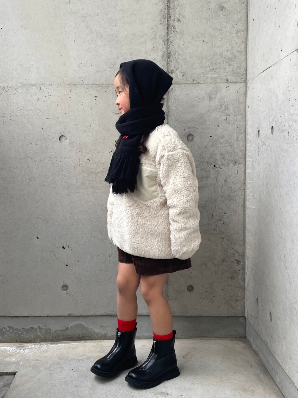 ブラウン系のその他パンツ、ホワイト系のトップス、ブラック系のブーツを着用したキッズの冬コーディネートの2枚目の写真