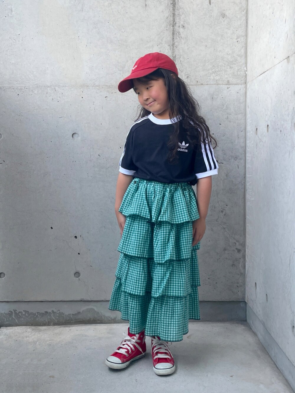 ブラック系のTシャツ/カットソー、レッド系のスニーカー、グリーン系のスカートを着用したキッズの秋コーディネートの4枚目の写真