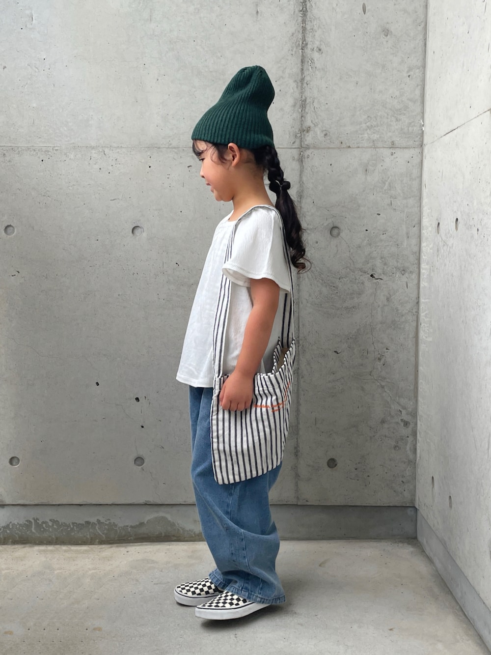 ホワイト系のキャミソール、ブラック系のスリッポン、ホワイト系のトップスを着用したキッズの秋コーディネートの2枚目の写真