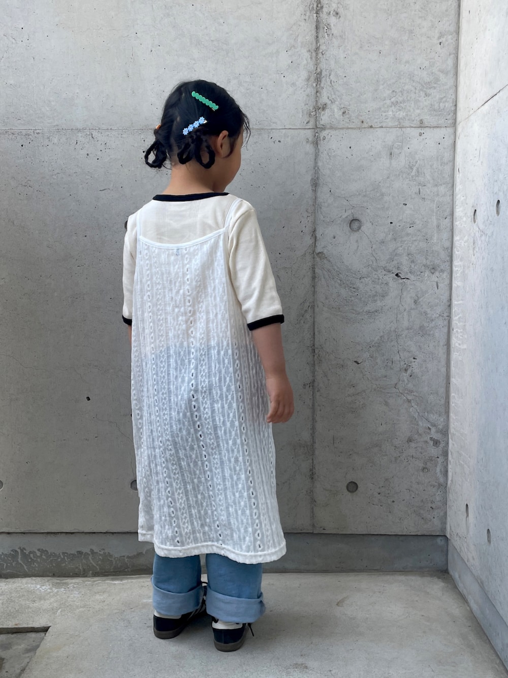 ホワイト系のワンピース、ホワイト系のTシャツ/カットソー、ブルー系のデニムパンツを着用したキッズの春コーディネートの2枚目の写真