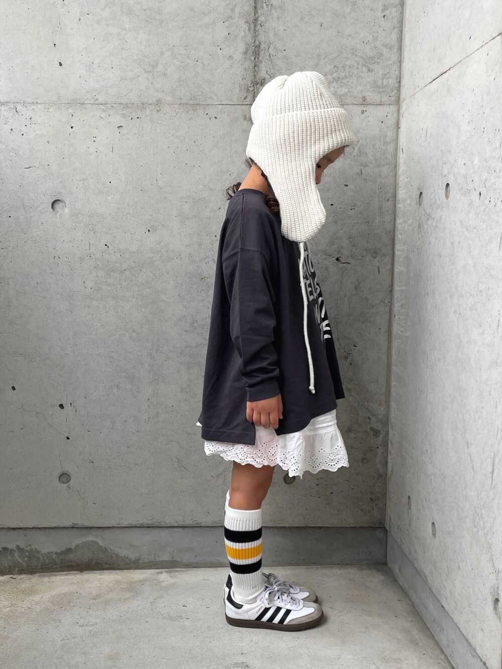 ホワイト系のパンツ、グレー系のTシャツ/カットソー、ホワイト系のスニーカーを着用したキッズの秋コーディネートの3枚目の写真