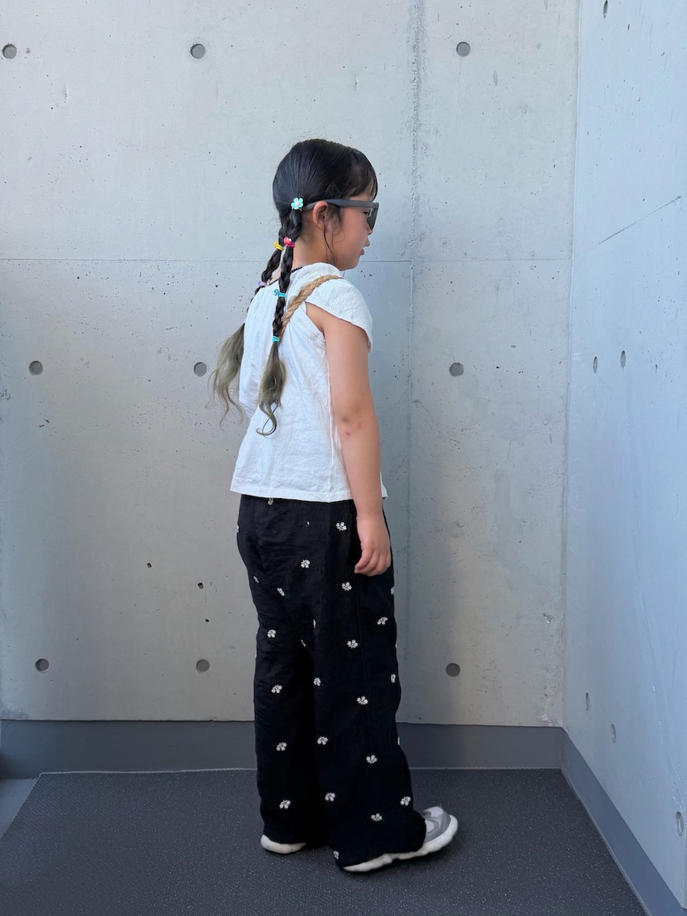 ブラック系のその他パンツ、ベージュ系のショルダーバッグ、シルバー系のスニーカーを着用したキッズの夏コーディネートの2枚目の写真