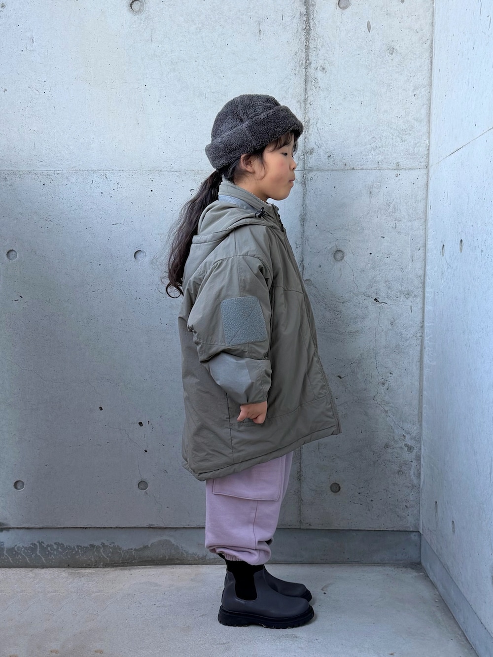 ピンク系のカーゴパンツ、グレー系のブーツ、グリーン系のブルゾンを着用したキッズの冬コーディネートの5枚目の写真