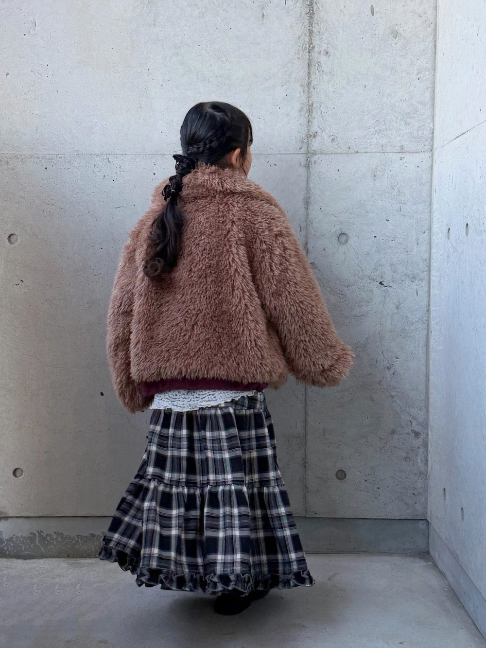 ブラウン系のブルゾン、ブラウン系のスカート、レッド系のスウェットを着用したキッズの冬コーディネートの3枚目の写真