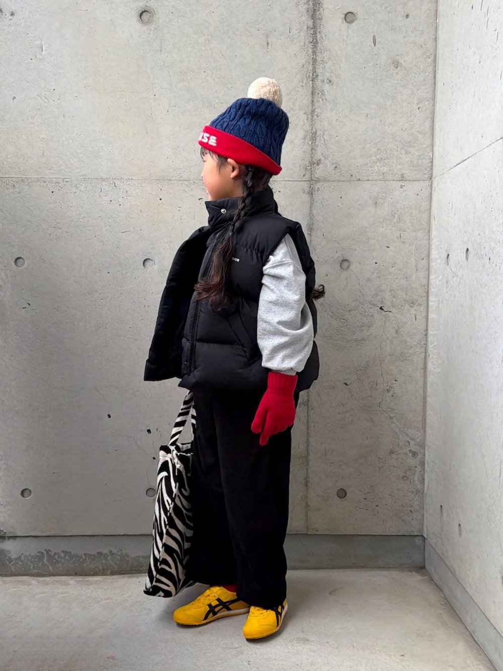 グレー系のスウェット、イエロー系のスニーカー、ブラック系のサロペット/オーバーオールを着用したキッズの冬コーディネートの2枚目の写真