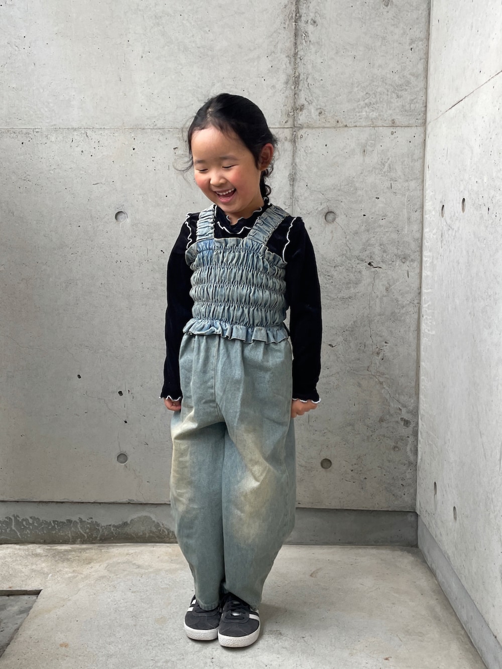 ブラック系のTシャツ/カットソー、ブルー系のオールインワン・サロペット、ブラック系のスニーカーを着用したキッズの春コーディネートの3枚目の写真