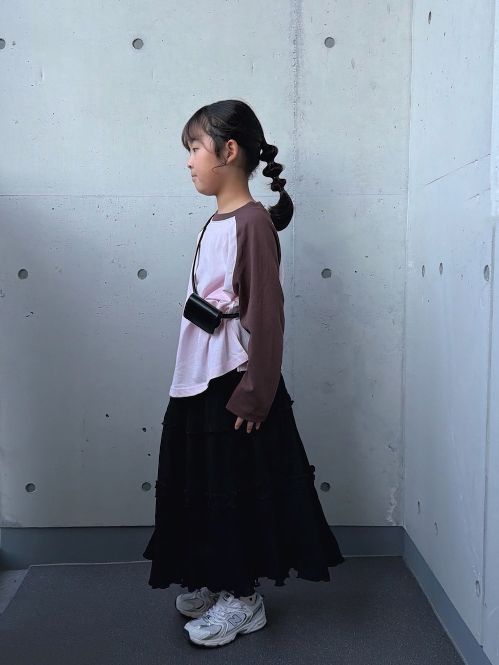 ホワイト系のスニーカー、ピンク系のTシャツ/カットソー、ブラック系のスカートを着用したキッズの秋コーディネートの3枚目の写真