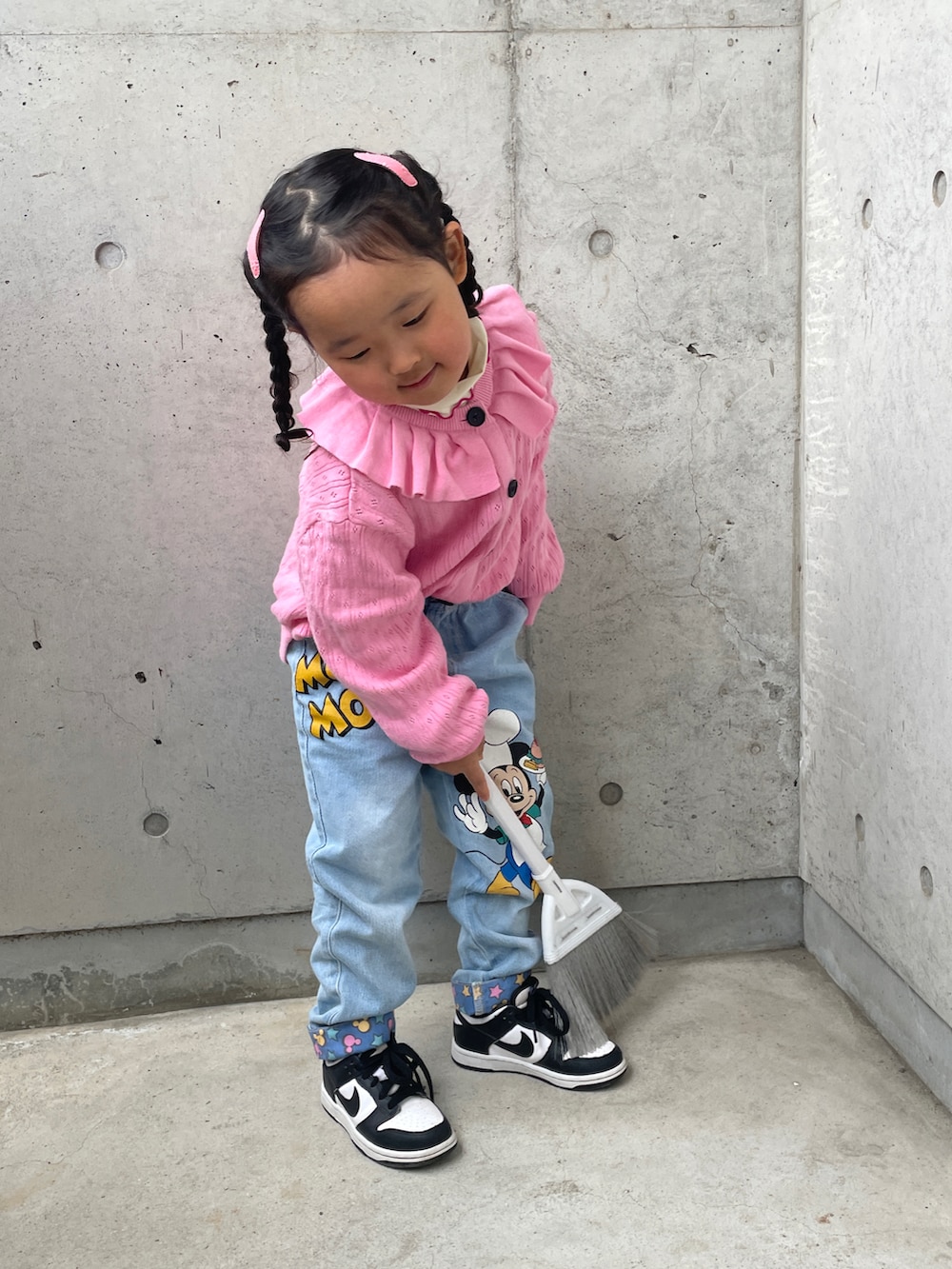 ブルー系のデニムパンツ、ブラック系のスニーカー、ピンク系のカーディガン/ボレロを着用したレディースの春コーディネートの2枚目の写真