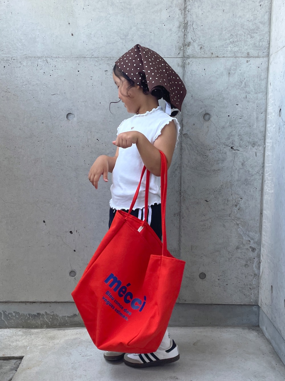 ブラック系のその他パンツ、ホワイト系のスニーカー、オレンジ系のトートバッグを着用したキッズの夏コーディネートの3枚目の写真