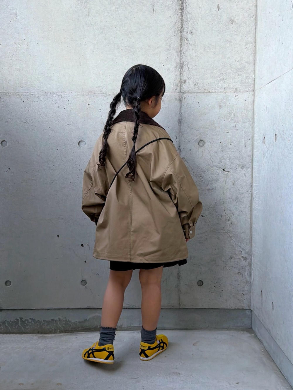 グレー系のTシャツ/カットソー、ベージュ系のミリタリージャケット、イエロー系のスニーカーを着用したキッズの秋コーディネートの3枚目の写真