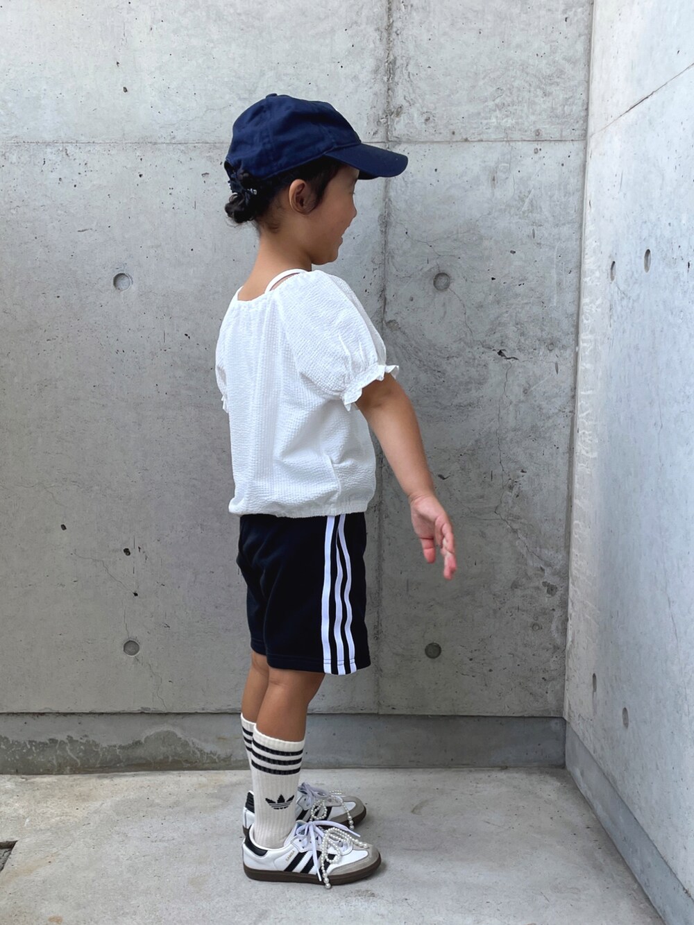 ホワイト系のトップス、ブラック系のその他パンツ、ホワイト系のスニーカーを着用したキッズの秋コーディネートの5枚目の写真