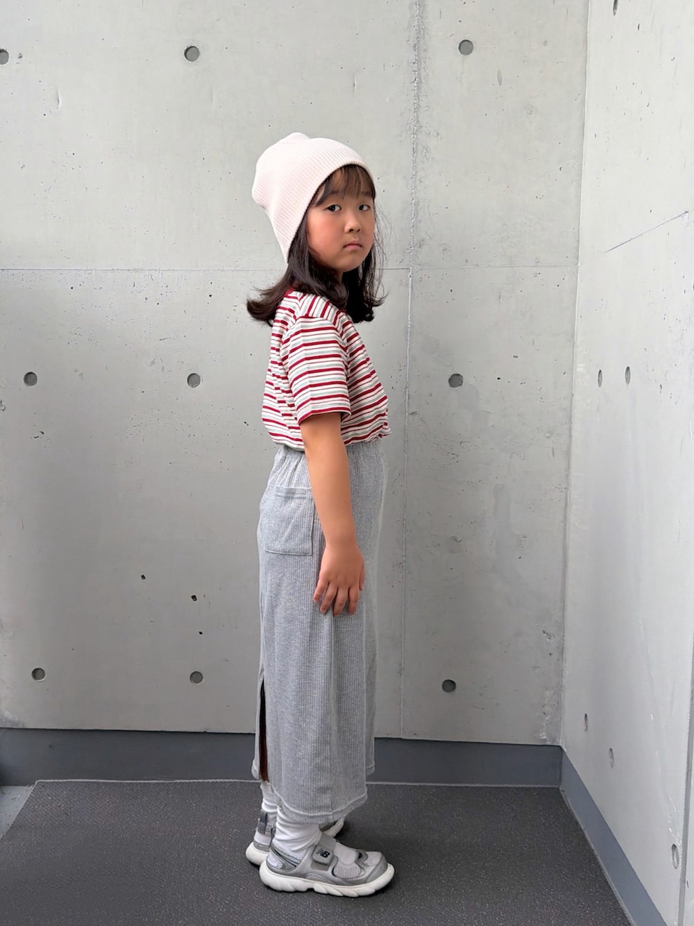 ホワイト系のTシャツ/カットソー、グレー系のスカート、シルバー系のスニーカーを着用したキッズの秋コーディネートの2枚目の写真