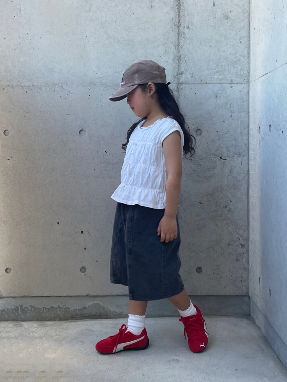 ブラック系のデニムパンツ、レッド系のスニーカー、ホワイト系のトップスを着用したキッズの夏コーディネートの3枚目の写真