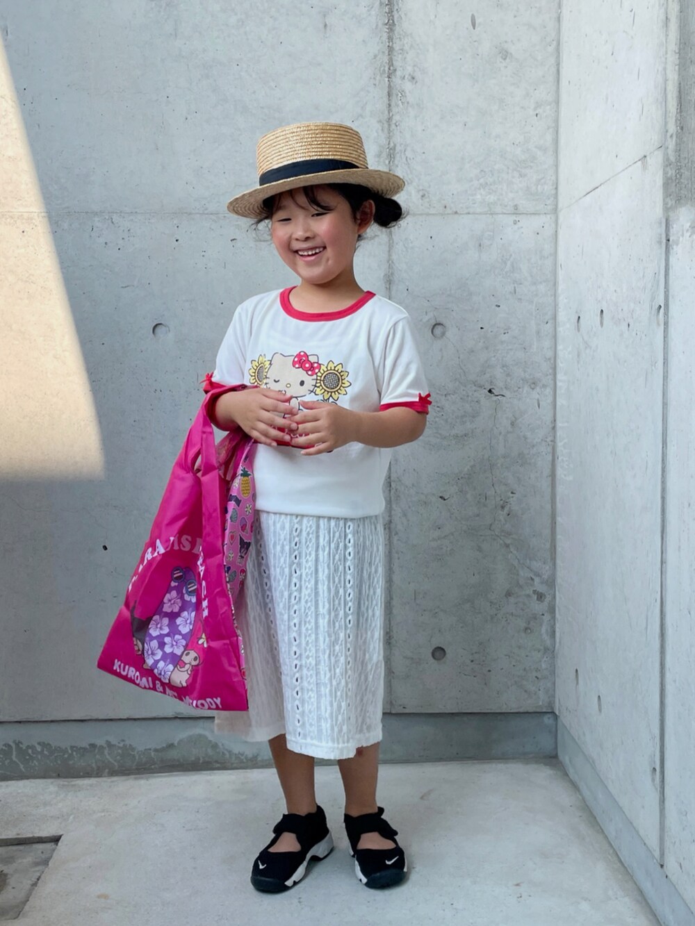 ホワイト系のワンピース、ブラック系のその他パンツ、ブラック系のスニーカーを着用したキッズの夏コーディネートの4枚目の写真