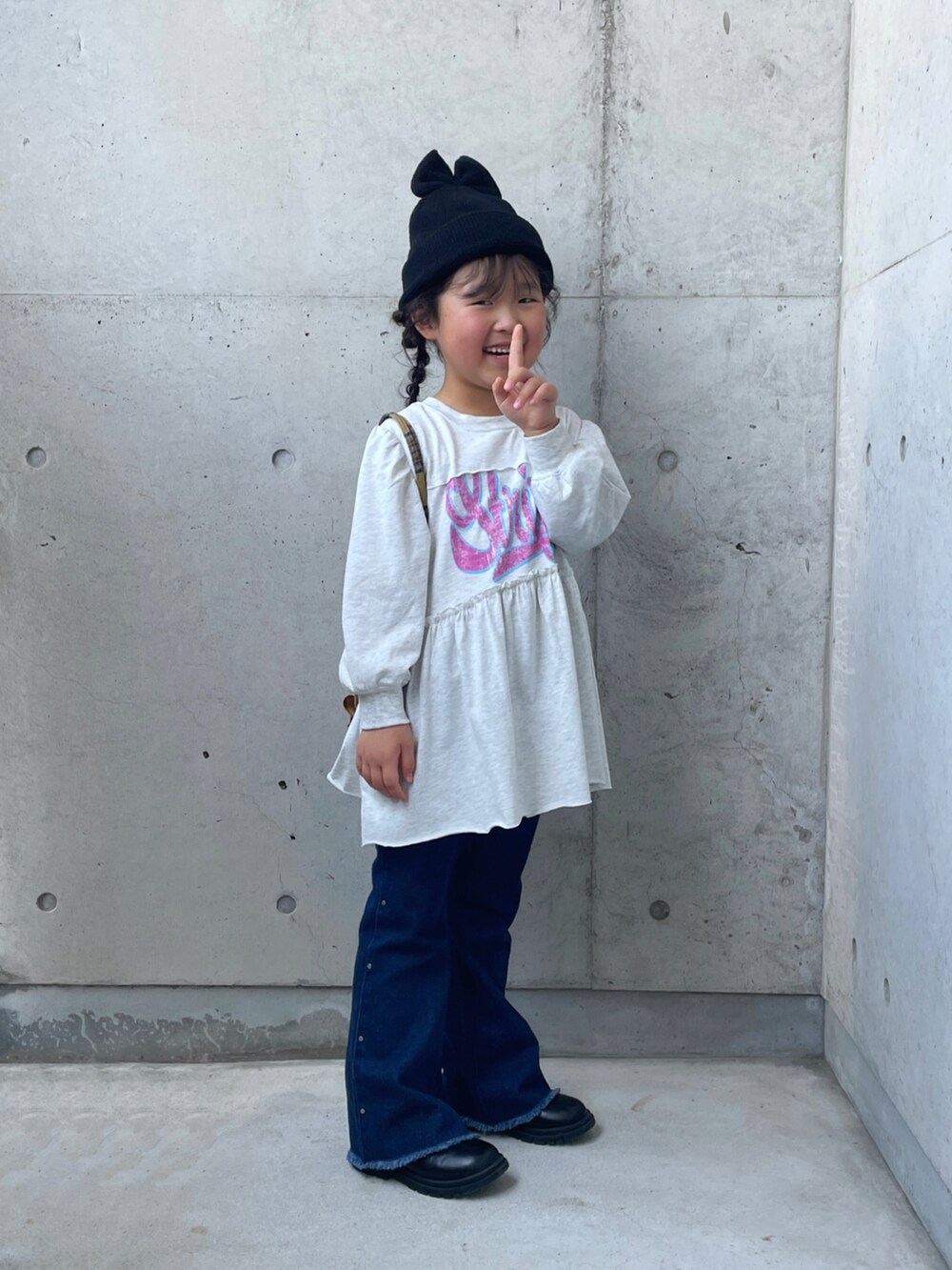 ブルー系のデニムパンツ、グレー系のワンピース、イエロー系のバックパック/リュックを着用したキッズの夏コーディネートの2枚目の写真