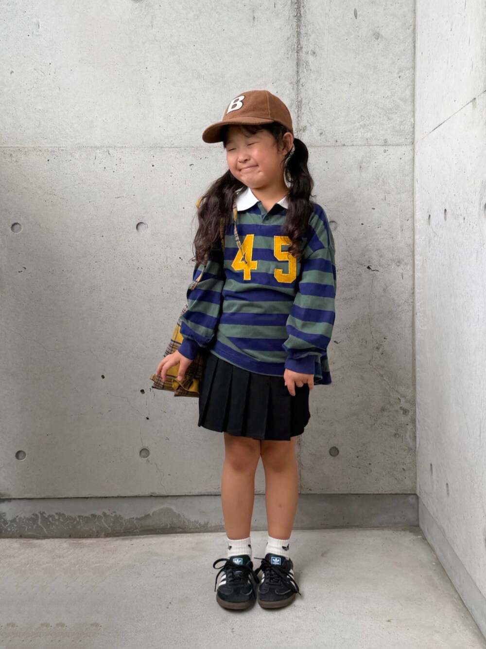 ブラック系のスニーカー、グリーン系のポロシャツ、イエロー系のバックパック/リュックを着用したキッズの秋コーディネートの5枚目の写真