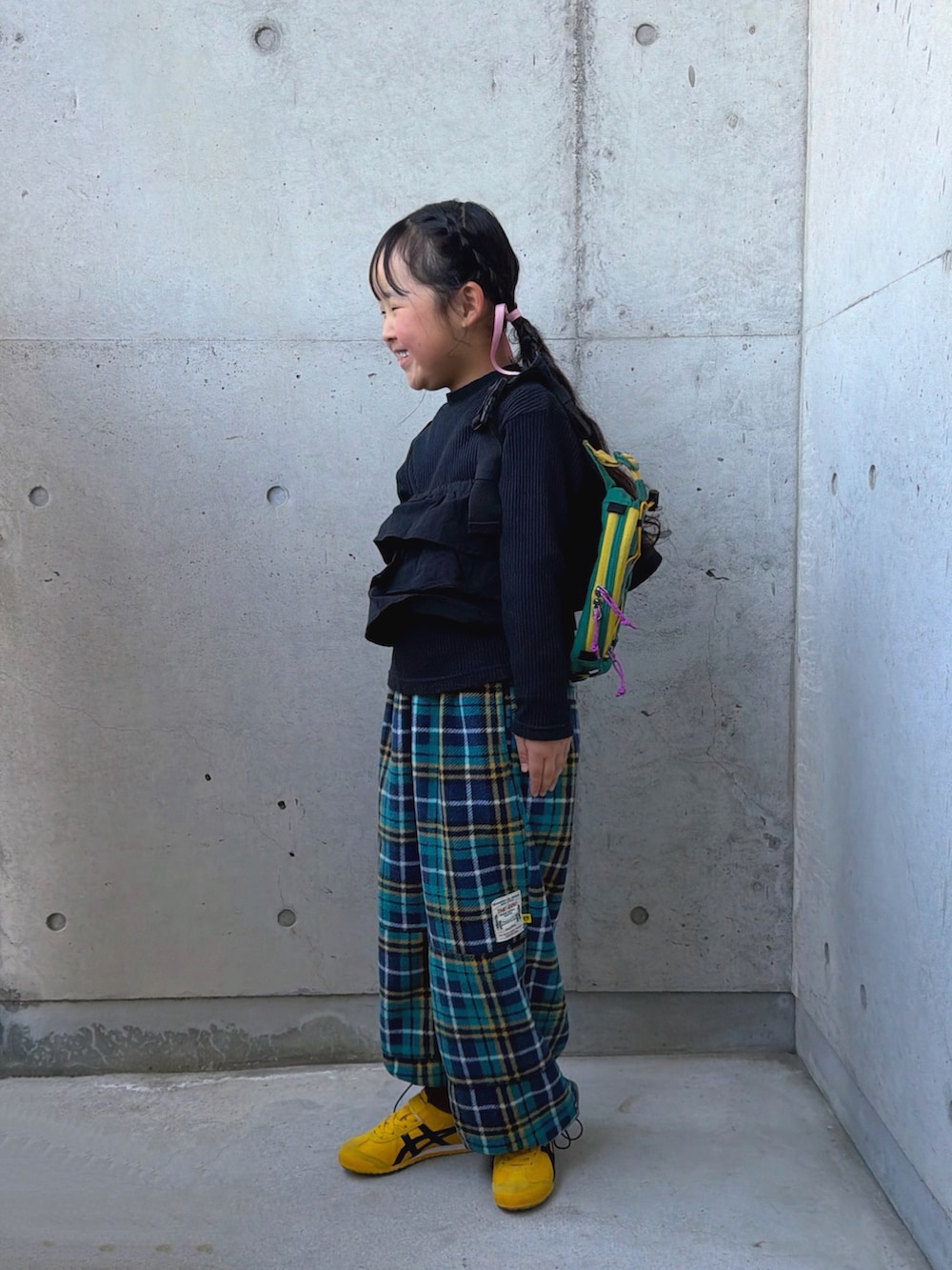 イエロー系のスニーカー、ブラック系のTシャツ/カットソー、グリーン系のパンツを着用したキッズの春コーディネートの2枚目の写真